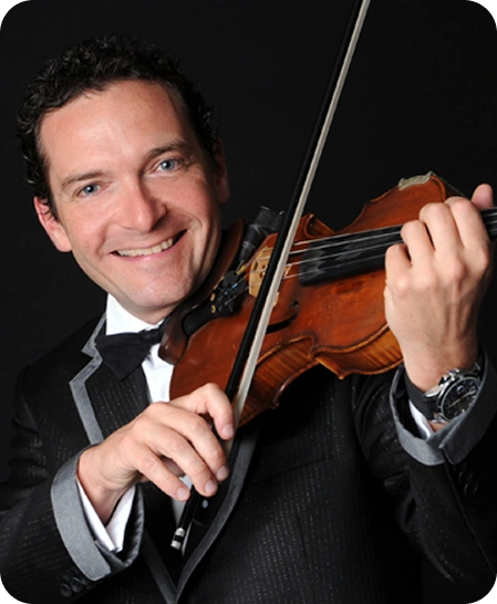 A professional headshot/portrait of a man playing the violin.